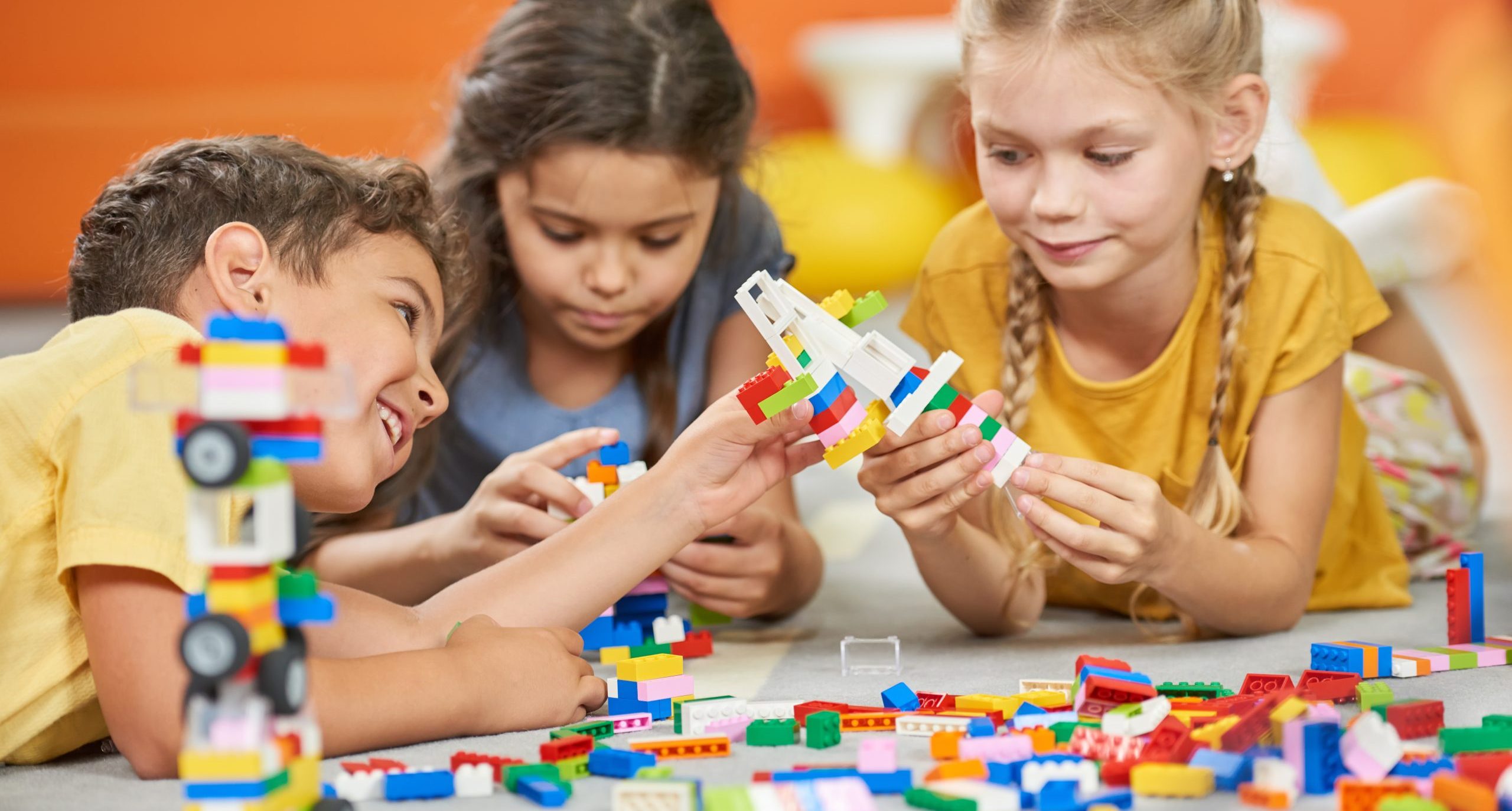 Group of kids playing with plastic blocks.